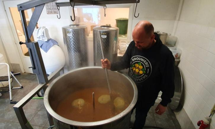 Man met roerstok door het bier aan het roeren
